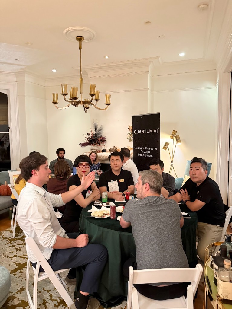Fellows gathered around a founding dinner table with the Quantum AI banner