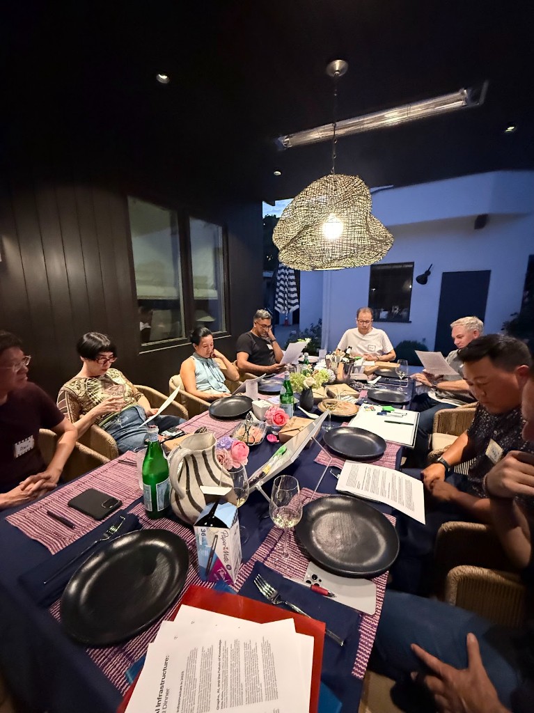 Outdoor founding dinner with fellows reviewing materials together